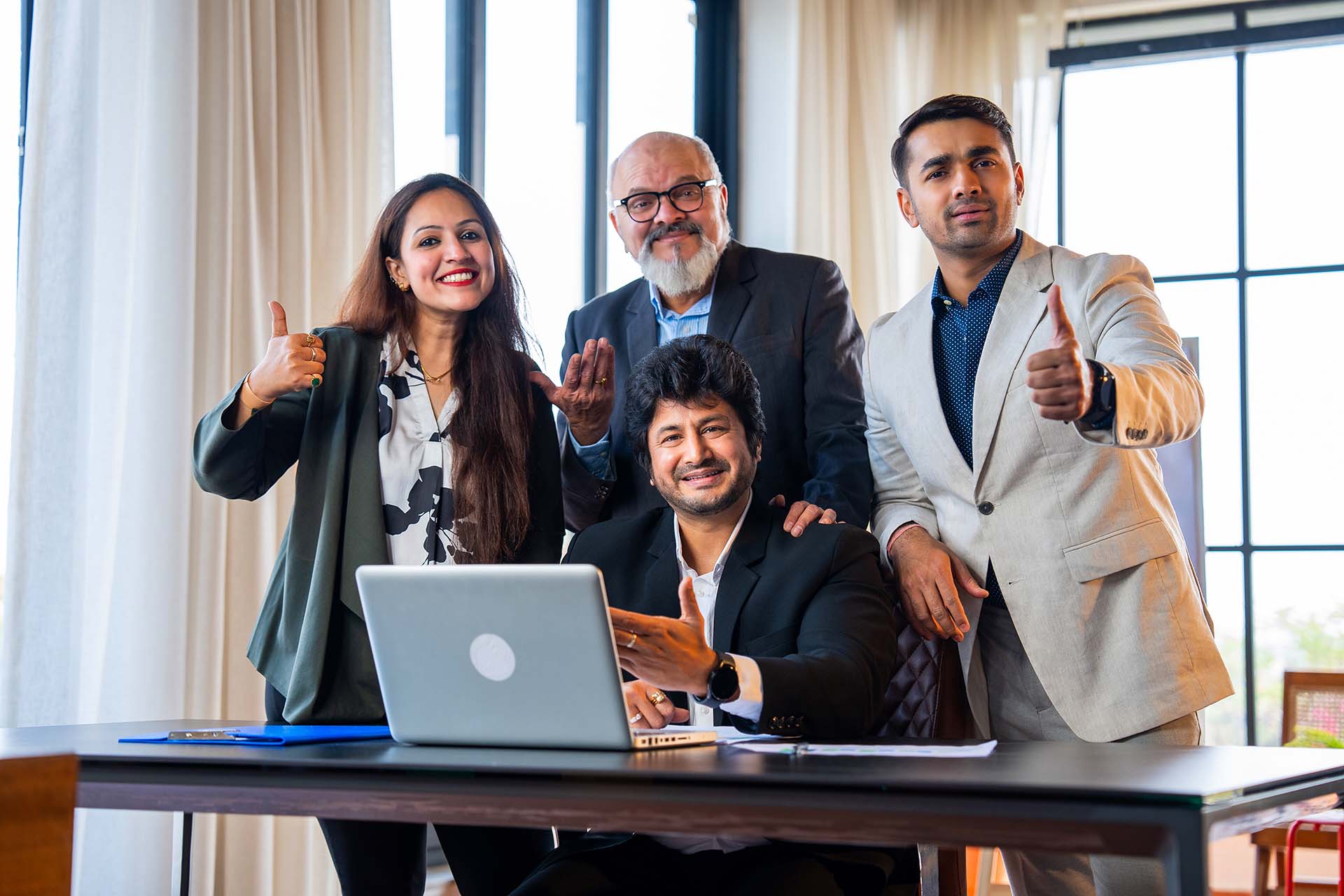 Indian business team celebrates success with high five and smiles in office environment